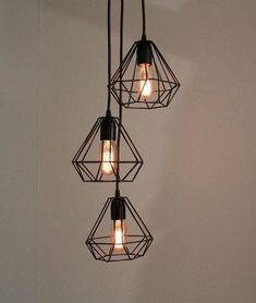 three light fixtures hanging from the ceiling in a room with white walls and flooring