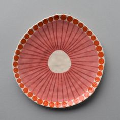 an orange and white plate sitting on top of a table