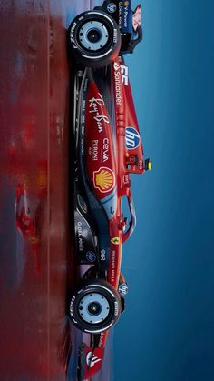 a red race car parked on top of a wooden wall