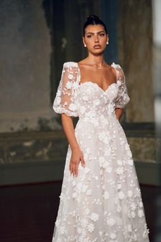 a woman in a white wedding dress with flowers on it