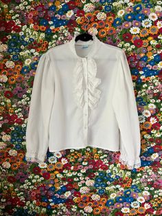 ♡ Vintage 70s/80s White Blouse Look Inc. Ruffle Button Down Peasant Pirate Blouse ♡ ❤ Lightweight white long sleeved button down blouse with ruffle collar. Sleeves ruffle at the wrists. Fabric has a smooth, cottony texture. DETAILS ❥ Size: No tags; ~Medium/Large ❥ Length: 23 inches ❥ Width: 22 inches ❥ Material: Cotton ❣ Brand: The Blouse Look Inc. ❣ No real visible signs of wear -- though I might have missed one! ❣ Previously owned/vintage/worn Pirate Blouse, White Button Up, Ruffle Shirt, White Button Down, Ruffle Collar, Button Down Blouse, Vintage Wear, White Blouse, Vintage 70s