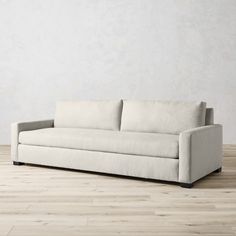 a white couch sitting on top of a hard wood floor