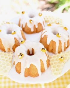 several bundt cakes with white icing and honey decorations on a yellow checkered tablecloth