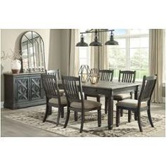 a dining room table and chairs in front of a window with an area rug on the floor