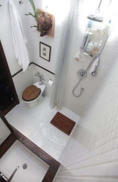 a bathroom with a sink, toilet and shower in it's stall area is seen from above