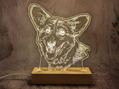 a wooden block with a laser cut image of a dog on it's face