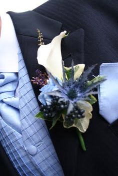 a man wearing a suit and tie with a boutonniere on his lapel