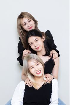 three young women are posing for the camera, one is holding another woman's hair