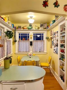 a kitchen with yellow walls and white cabinets