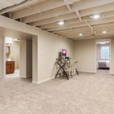 an empty room with chairs, table and television