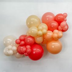 an assortment of balloons are arranged on a white surface