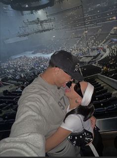 a man and woman kissing in front of an audience at a concert or performance venue