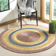 a round rug in the corner of a room with a chair and potted plant