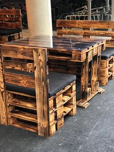 wooden tables and chairs made out of pallet wood with black leather seat covers on them