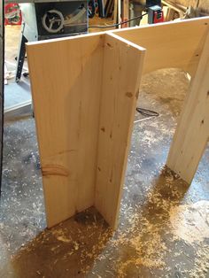 two pieces of wood sitting on top of a table in a room filled with tools