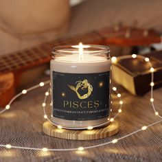 a candle sitting on top of a table next to a string of lights and a guitar