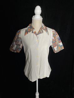 "1960's white cotton button up blouse with colorful batik sleeves and collar. Great vintage condition Women's small/medium, labeled size 34 Bust: 38\" Shoulder to hem: 23\" Back shoulders: 14.25\"" Button Up Blouse, Cotton Blouse, Short Sleeve Button Up, Cotton Blouses, Short Sleeve Button, Vintage 1960s, White Cotton, Chef's Jackets, Batik