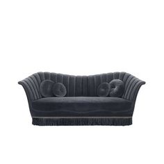 a black velvet couch with tassels on the legs and back ends, in front of a white background