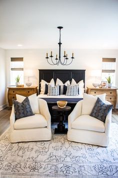 a living room filled with furniture and a chandelier hanging over the top of it