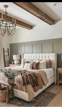 a bedroom with a large bed and chandelier hanging from it's ceiling