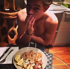 a man sitting at a table with a plate of food in front of his face