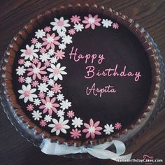 a birthday cake with pink and white flowers on it