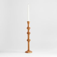 a tall wooden candle holder with a white candle