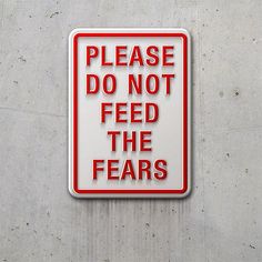 a sign that says please do not feed the fears on a concrete wall background