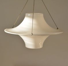 a white light fixture hanging from a ceiling in a room with no one around it