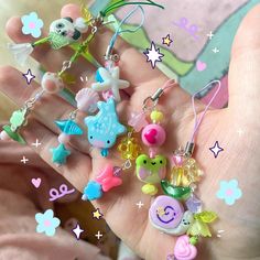 a hand holding several charms in it's palm, with other items on them