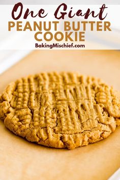 one giant peanut butter cookie sitting on top of a piece of parchment paper with the words, one giant peanut butter cookie