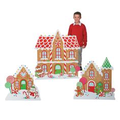 a boy standing in front of three gingerbread houses