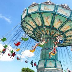 people are riding on the swings at an amusement park