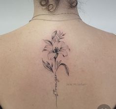 a woman's back with a flower tattoo on it