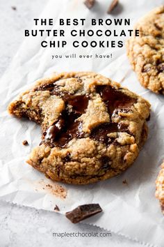 two chocolate chip cookies on top of white paper