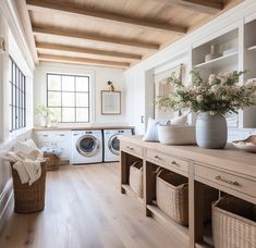 a washer and dryer in a room with wood floors, white walls and ceiling