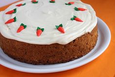 a cake with white frosting and strawberries on top sits on a plate, ready to be eaten