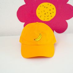 A fun hat with an embroidered banana! It has an unstructured style and antiqued brass side buckle, giving this cap that perfect, casual-cool look. It's vintage cool with six panels and with a pre-curved bill. Made from 100% cotton chino fabric. One size fits most. Embroidered in SF! Adjustable Curved Brim Fun Dad Hat, Retro Adjustable Dad Hat With Curved Visor, Trendy Dad Hat With Curved Bill, Trendy Yellow Baseball Cap With Visor, Trendy Yellow Visor Baseball Cap, Trendy Yellow Snapback Dad Hat, Fun Adjustable Baseball Cap For Everyday Wear, Trendy Adjustable Yellow Dad Hat, Trendy Adjustable Curved Visor Hat