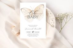 a white card with a butterfly on it next to some baby's breath flowers