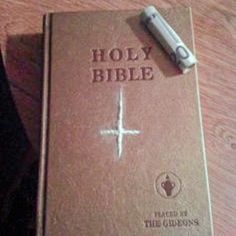 a brown bible with a pen on top of it