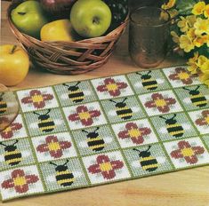 a table topped with apples and flowers next to a basket of fruit