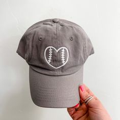 a baseball cap with a heart shaped stitching on the front, and a football in the middle