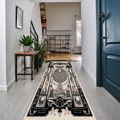 a black and white rug on the floor in front of a blue door with an ornate design