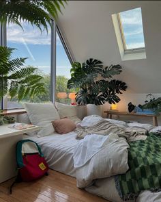 a bedroom with large windows and lots of plants