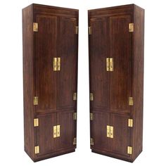 a pair of wooden cabinets with brass hardware on the doors and drawers, both side by side