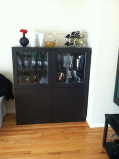 a black cabinet sitting on top of a hard wood floor