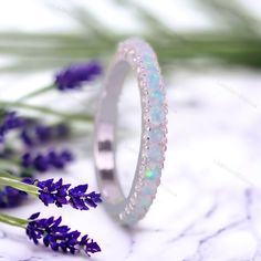 an opalite ring sits next to lavender flowers