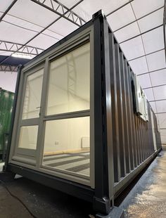 a large metal container sitting inside of a building next to a green box on the ground