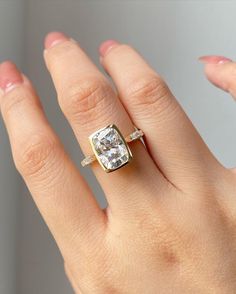 a woman's hand with a ring on it and a diamond in the middle