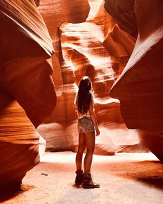 a woman standing in the middle of a canyon